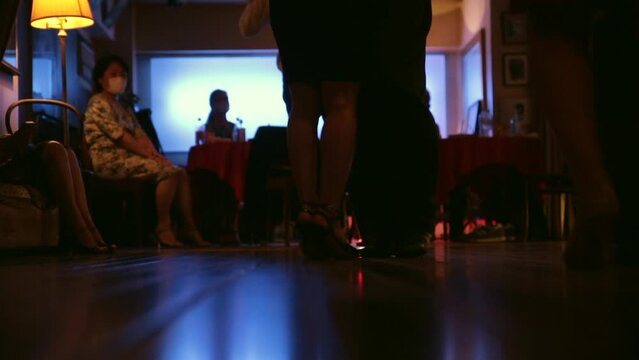 foot steps in the floor of a milonga dancing Argentine Tango in a moody bar cafe	