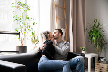 Romantic Couple Sharing a Tender Kiss in a Brightly-Lit room at home, close up shot