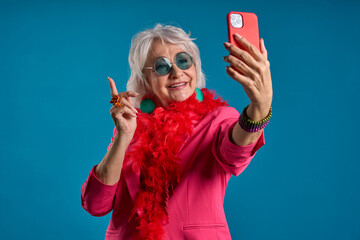 Senior lady capturing the moment on smartphone - Senior selfie concept