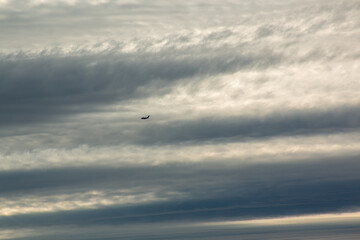 A military transport jet against a cloudy sky over Seattle