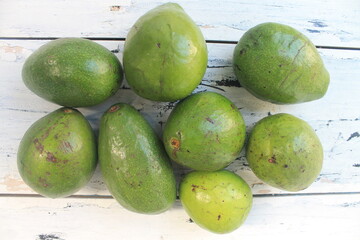 Bunch of avocados on white table