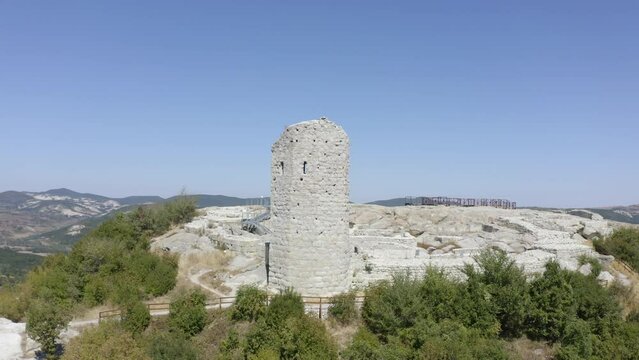 Drone orbiting around the palace complex of the ancient historical landmark of Perperikon, showing a high tower with a viewdeck, located in the province of Kardzhali in Bulgaria.