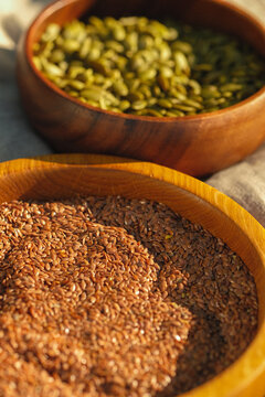 two wodden bowls with pumplin seeds and milk thistle