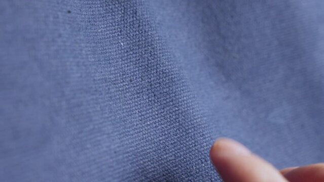 Human Hand. Finger Touching Blue Cotton Fabric. Close-up Shot
