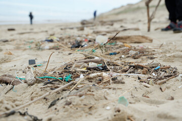 Déchets plastiques et divers objets sur le sable en bord de plage. Détritus sur la plage. 