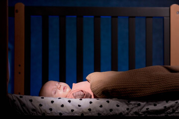 Cute little baby sleeping in cradle at home night