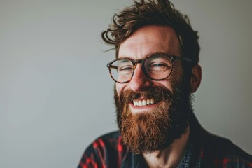 Portrait of a handsome bearded hipster man wearing glasses and a plaid shirt - obrazy, fototapety, plakaty