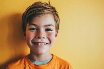 Portrait of a smiling boy on a yellow background. Emotions