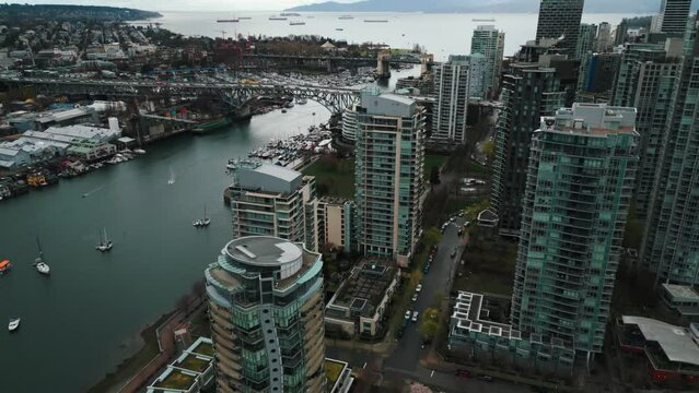 drone shot revealing granville island street bridge in Vancouver City and the ocean in the background on an overcast day, british columbia, canada