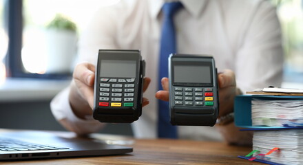 Male businessman hand hold two wireless device pos terminal closeup.