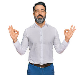 Middle aged man with beard wearing casual white shirt relax and smiling with eyes closed doing meditation gesture with fingers. yoga concept.