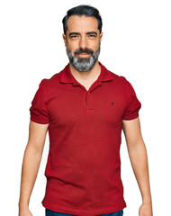 Middle aged man with beard wearing casual red t shirt looking positive and happy standing and smiling with a confident smile showing teeth