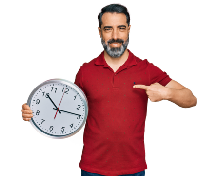 Middle aged man with beard holding big clock pointing finger to one self smiling happy and proud