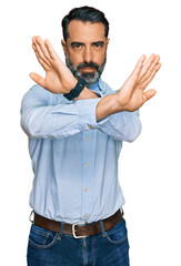 Middle aged man with beard wearing business shirt rejection expression crossing arms and palms...