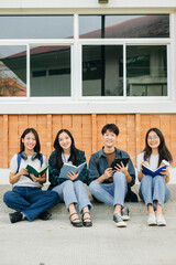 Obraz premium Young Asian college students and a female student group work at the campus park