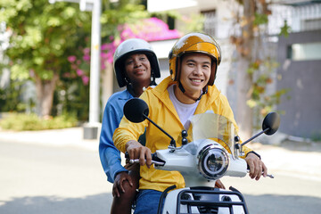 Portrait of smiling Vietnamese man working as motorbike taxi driver