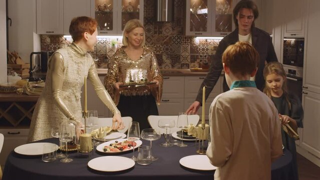 Slow motion shot footage of big family with kids preparing to celebrate Christmas setting festive table together
