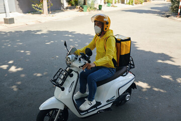 Courier riding motorbike when delivering orders