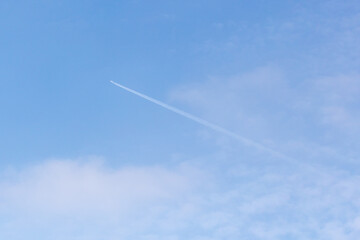 Blue sky with white clouds and contrail in the clear day