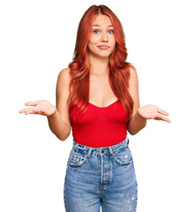 Young redhead woman wearing casual clothes clueless and confused expression with arms and hands...