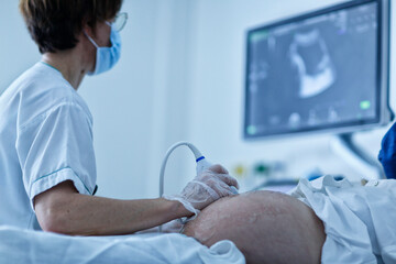 doctor examining patient, Patient undergoing ultrasound scanning in a hospital ward (selective focus) - obrazy, fototapety, plakaty