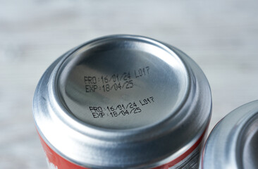 Close-up of the expiration date on a can of beer. Light background.