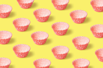 Pink paper baking cases on the bright yellow background