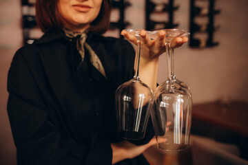 female sommelier holding empty glasses