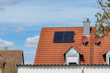 Rotes Hausdach mit Solarthermie-Kollektoren - obrazy, fototapety, plakaty