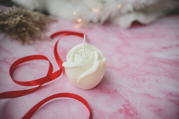 Cute rose shaped soy wax candle on pink background