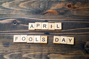 April fools day letter made by wooden cubes on a dark grunge desk.