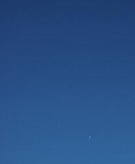 Last quarter half moon over blue sky