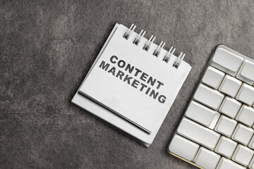 Keyboard and notebook with content marketing text