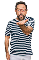 Obraz premium Middle age man wearing casual clothes and glasses looking at the camera blowing a kiss with hand on air being lovely and sexy. love expression.