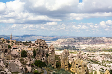 Fototapeta na wymiar Panoramic view of Uchisar town with its unique rock formations against a dramatic sky in Cappadocia, Turkiye (Turkey)