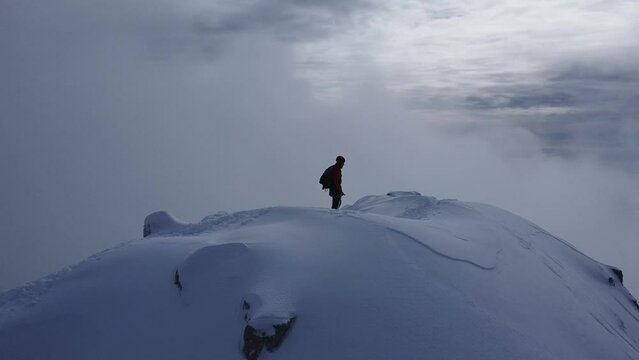 Hiker walking on snowy Orobie ridge in the breathtaking Alps of Lecco