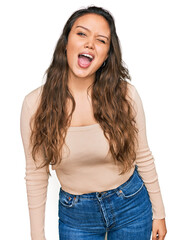 Fototapeta premium Young hispanic girl wearing casual clothes winking looking at the camera with sexy expression, cheerful and happy face.