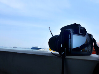 Camera dslr closed up above wall with sea and ship view	