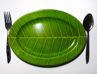 Empty green plate leaf pattern theme with spoon and fork isolated white background