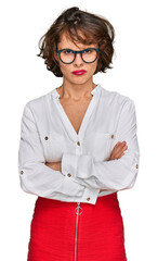 Young hispanic woman wearing business style and glasses skeptic and nervous, disapproving...