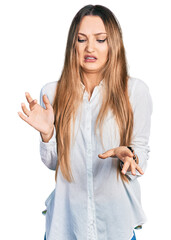 Fototapeta premium Beautiful caucasian woman wearing casual white shirt disgusted expression, displeased and fearful doing disgust face because aversion reaction.