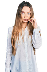 Beautiful caucasian woman wearing casual white shirt mouth and lips shut as zip with fingers....