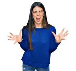 Young hispanic woman wearing casual clothes crazy and mad shouting and yelling with aggressive...