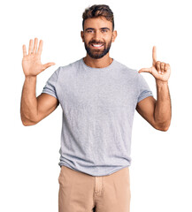 Young hispanic man wearing casual clothes showing and pointing up with fingers number seven while smiling confident and happy.