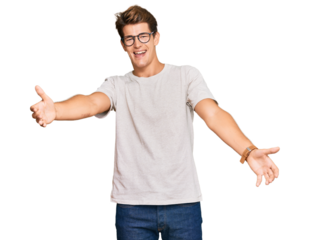 Handsome caucasian man wearing casual clothes and glasses looking at the camera smiling with open arms for hug. cheerful expression embracing happiness.