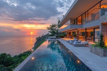 Obraz premium Luxury modern house with infinity pool and outdoor living area by the sea