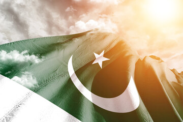Pakistan national flag cloth fabric waving on beautiful cloudy Background.