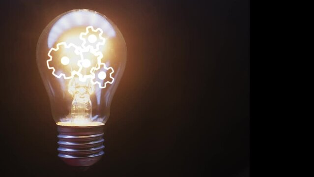 Rotating gears inside a light bulb in which the light turns on and off on a black background. Technological footage. Cg