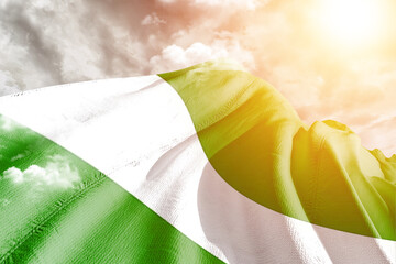 Nigeria national flag cloth fabric waving on beautiful cloudy Background.