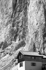 Vertical view of an ancient mountain hut in the famous Dolomites mountains, Italy, close to the "Torri del Vajolet" (Vajolet rock towers). Monochromatic.